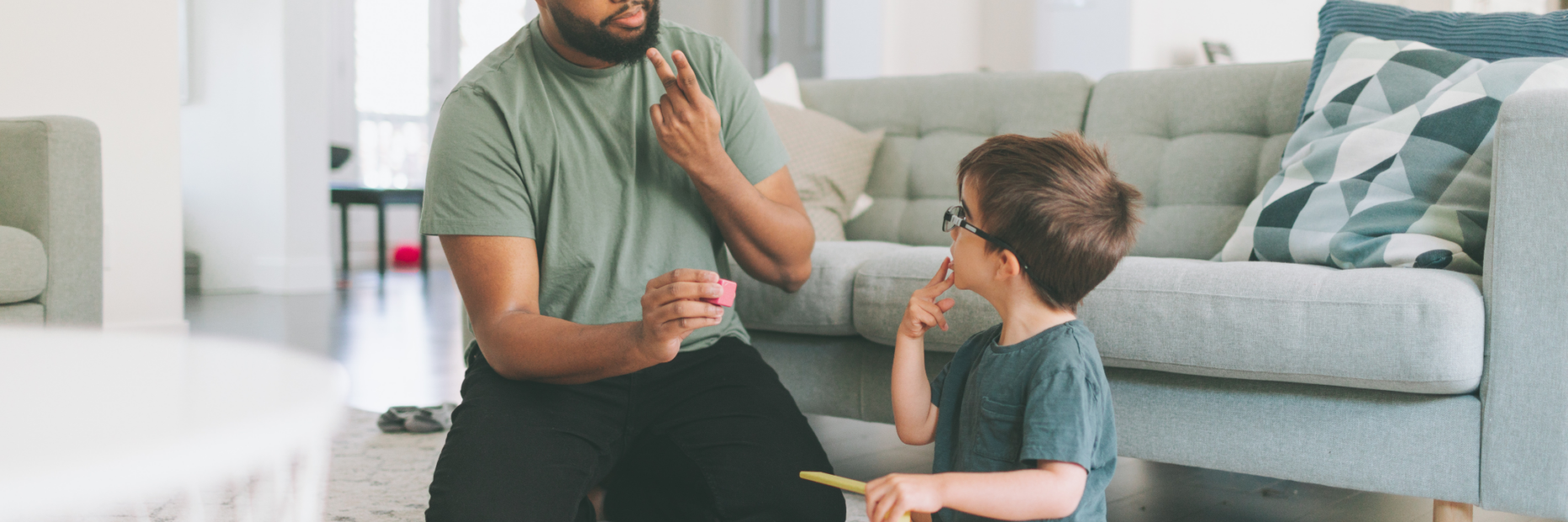 Men teaching toddler ASL